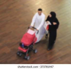 Arab sheikhs men and their wives and families in a mall make a purchase, Dubai, people go to the mall, market, blurred for background