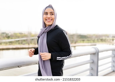 Arab sportswoman in hijab jogging on the street at sunset - Shutterstock ID 2151832203