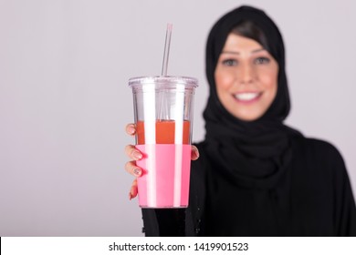 Arab woman feeling happy while having a juice. Close Up Of Woman Holding Cup With Smoothie. - Powered by Shutterstock