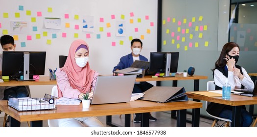 Arab Woman Wear  Hijab Work In Socially Spaced Offices And Everyone In The Office Wear A Mask Prevent Spread From Coronavirus. 