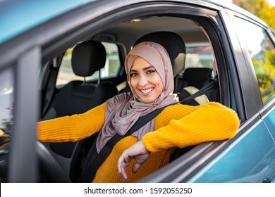 Arab Women Driving Car. Young Muslim Female Driver. Smiling Muslim Woman Driving Her Vehicle. Beautiful Muslim Woman With Toothy Smile Driving Car. 