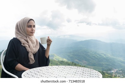 Arab Women In Hijab Holding Coffee On The  Mountain View Background. 