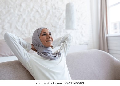 Arab young businesswoman in hijab relaxing on sofa at home after hard busy day at work. - Powered by Shutterstock