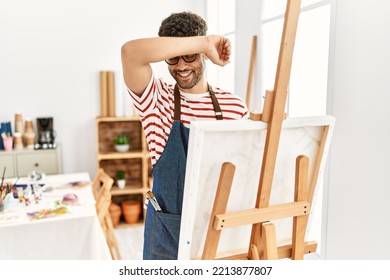 Arab Young Man At Art Studio Smiling Cheerful Playing Peek A Boo With Hands Showing Face. Surprised And Exited 