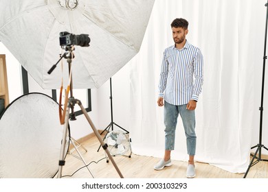 Arab Young Man Posing As Model At Photography Studio Skeptic And Nervous, Frowning Upset Because Of Problem. Negative Person. 