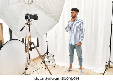 Arab Young Man Posing As Model At Photography Studio Thinking Worried About A Question, Concerned And Nervous With Hand On Chin 