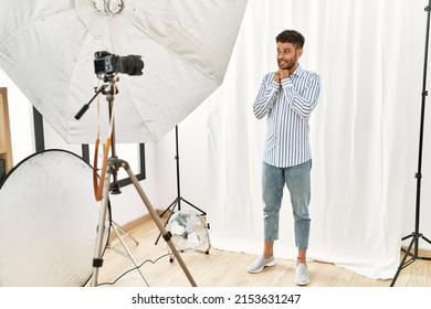 Arab Young Man Posing As Model At Photography Studio Laughing Nervous And Excited With Hands On Chin Looking To The Side 