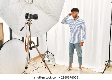 Arab Young Man Posing As Model At Photography Studio Worried And Stressed About A Problem With Hand On Forehead, Nervous And Anxious For Crisis 