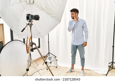 Arab Young Man Posing As Model At Photography Studio Hand On Mouth Telling Secret Rumor, Whispering Malicious Talk Conversation 