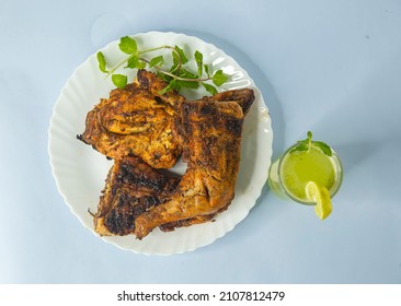 Arabian - Asian spicy food concept - homemade tandoori chicken Leg piece served with salads . Lime juice 