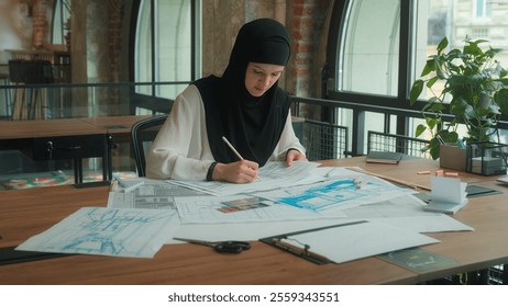 Arabian business muslim woman in hijab architecture paperwork ethnic female architect engineer designer islamic businesswoman girl drawing building plan blueprint scheme engineering work in office - Powered by Shutterstock