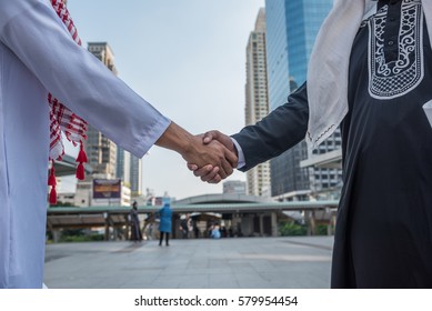 Arabian Businessman Partner Shaking Hands Together On City Background, Saudi Arabia Successful Business Culture Teamwork Concept.