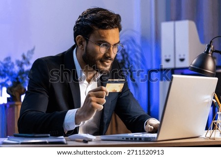 Arabian businessman programmer software developer working making online purchase payment shopping with credit bank card and use laptop at home office desk with laptop. Indian freelancer business man
