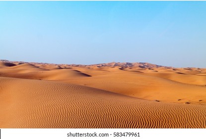 Arabian desert dune background on blue sky. Desert near the city of Dubai. many dunes stretching out into the distance on the background of clear sky