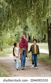 Arabian Family Walking Under Willow Tree In Park