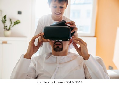 Arabian Father And Son Using VR Headset At Home - Powered by Shutterstock