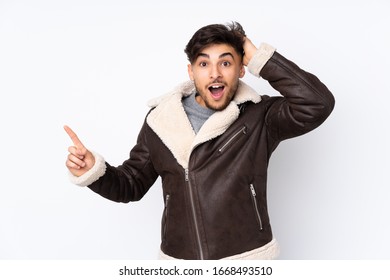 Arabian handsome man over isolated background surprised and pointing finger to the side