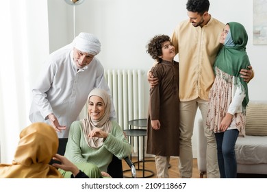 arabian man hugging interracial kids near muslim family at home
