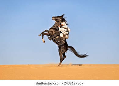 Arabian man triumphing in battle and rearing his horse while holding his bow and arrow - Powered by Shutterstock