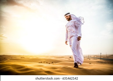 Arabian Man Walking  In The Desert At Sunrise