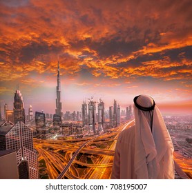 Arabian man watching  cityscape of Dubai with modern futuristic architecture in United Arab Emirates.
