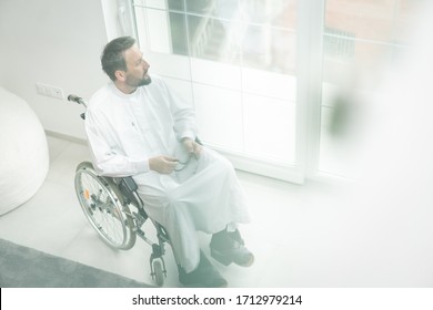 Arabian middle aged man in wheelchair at home