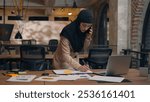 Arabian muslim woman female office lady businesswoman islamic in hijab busy multitasking organizer planner manage business tasks write notes stickers talk mobile phone call consult work online laptop