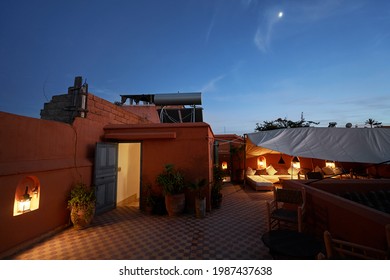 Arabian night. Traveling by Morocco. Relaxing in festive moroccan traditional riad interior in medina. Comfortable terrace filled with soft, cozy furniture.