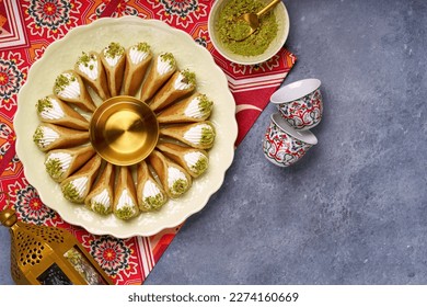 Arabian pancake Qatayef with qishta cream and pistachio . Traditional sweets with ramadan decor .                               