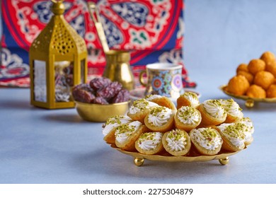 Arabian pancake Qatayef with qishta cream and pistachio . Traditional sweets with ramadan decor                              