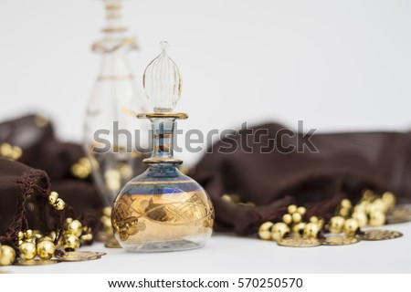 Arabian parfum bottles and brown belly dance belt with golden coin. Blurred photography, selective focus on glass decorations.