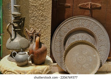 Arabian-style Cookware In The Street Souvenir Store.Traditional Gulf And African Countries Utensil, Ancient Brass Trays And Silver Kettle, Jug With Oriental Pattern On Display Of Middle Eastern Souk.