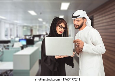 Arabic Business People Standing Side By Side With Laptop Discussing New Projects In Office Hall