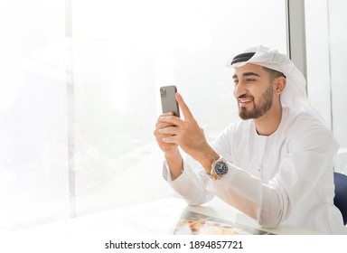 Arabic Corporate Business Man Wearing Kandora Looking At Mobile Phone And Smiling - Portrait Of Traditional Emirati Man