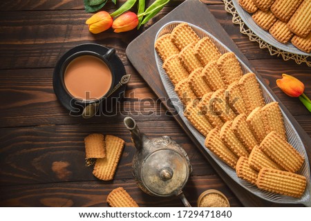 Arabic Cuisine; Cookies for celebration of El Fitr Islamic Feast (The Feast that comes after Ramadan). Delicious traditional biscuits served with cup of tea and milk. Top view with copy space.