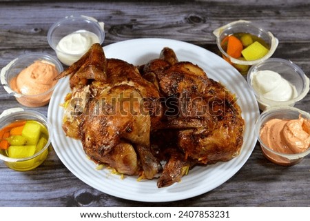Arabic cuisine of machine grilled barbecued chicken, a whole chicken barbecued in a chicken grill machine, chickens made with the Syrian recipe, moist, juicy, usually served with rice and garlic sauce