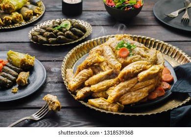 Arabic cuisine; Middle eastern traditional "Mahshy" or "Dolma" dishes.Stuffed cabbage rolls, vine leaves, zucchini, eggplant and peppers. Served with green salad, fresh lemon and yogurt sauce.  - Shutterstock ID 1318539368