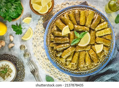 Arabic Cuisine; Traditional delicious stuffed vine leaves. Served with yogurt salad and fresh lemon. Top view with close up. - Shutterstock ID 2137878435