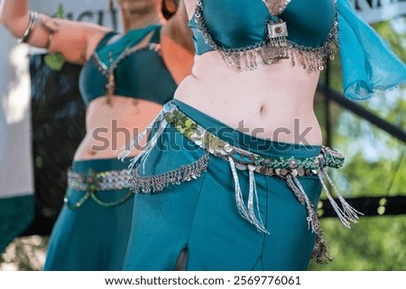Arabic dancer dancing on a stage. Ballerina hips moving to the rhythm of the music. Bellydancer on stage. Beautiful bellydancers dancing and moving their hips