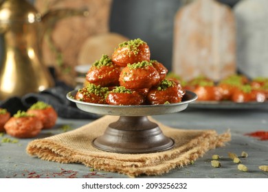 Arabic dessert Middle Eastern traditional dessert Ramadan dessert "Zalabya",or Luqmat Al-Kadi, Sub Alqafsha served with honey, pistachio cinnamon, sugar and oriental tea. Close up with copy space. - Shutterstock ID 2093256232