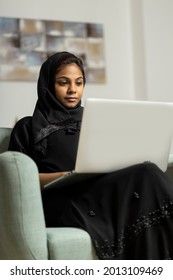 Arabic lady wearing black abaya (Traditional dress) working on a laptop computer