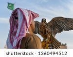 Arabic man from Saudi Arabia wears traditional clothes and holding trained falcon