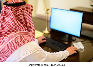 Arabic man from Saudi Arabia working at home to protect him self from the viruses pandemic COVID-19 "corona". - Shutterstock ID 1684565563