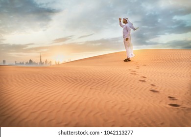 Arabic Man With Traditional Emirates Clothes Walking In The Desert