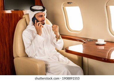 Arabic man wearing kandora in emirates style flying on exclusive private jet - Middle-eastern businessman with traditional dress flies in exclusive business class on airplane - Powered by Shutterstock