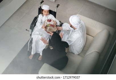 Arabic man in wheelchair with family at home