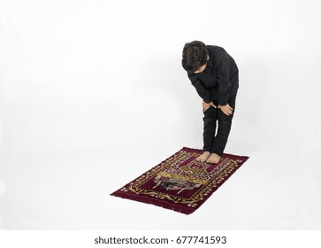 Arabic Muslim Boy Praying On A Prayer Mat Rug Isolated On White