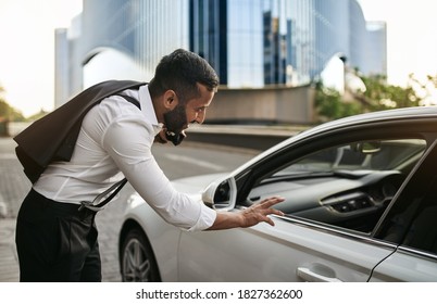 Arabic Muslim Businessman With Jacket On Shoulder Calling And Talking To Taxi Cab Driver For Lift From Work In The City