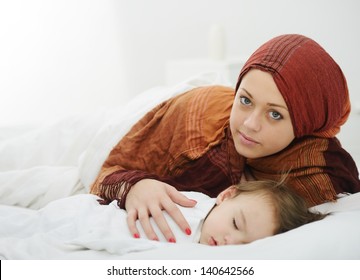 Arabic Muslim Mother Playing And Taking Care Of Her Baby