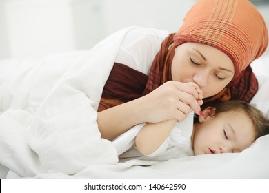 Arabic Muslim Mother Playing And Taking Care Of Her Baby